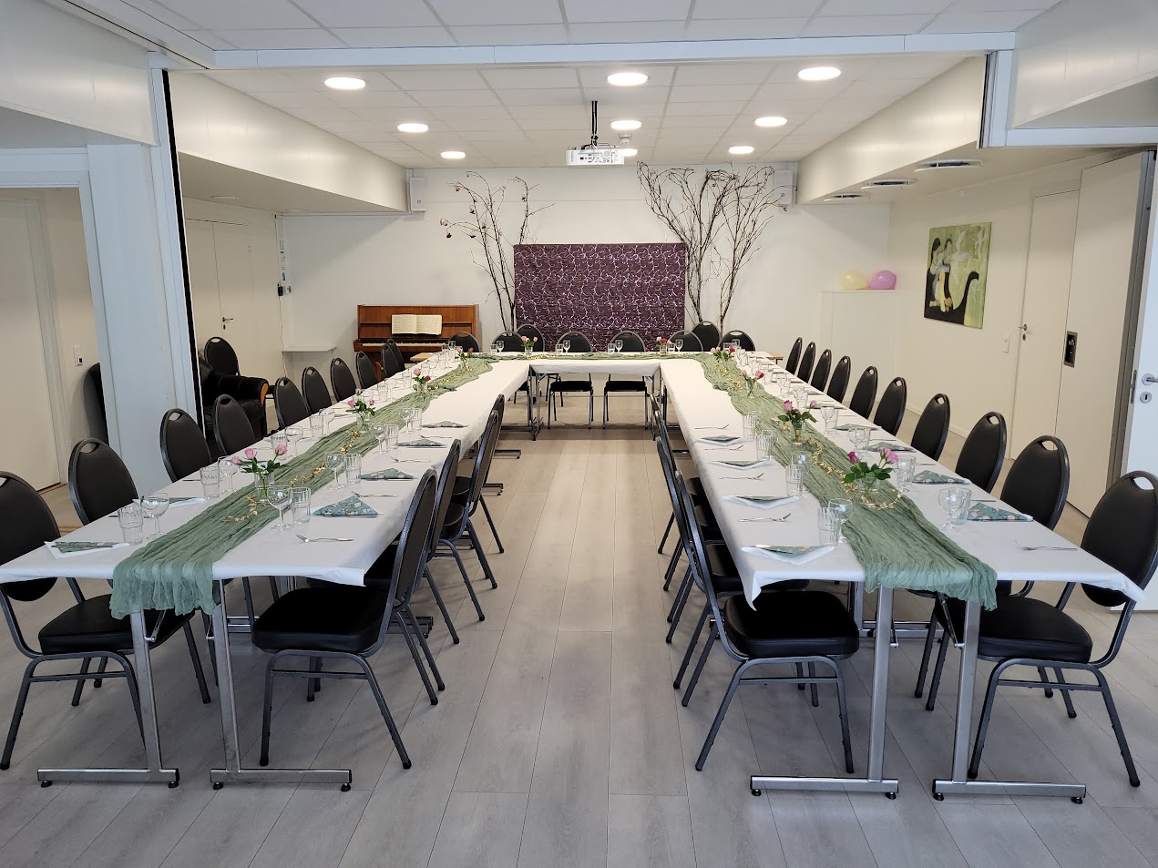 Menighetssalen, hvite vegger, grått gulv, dekket på til selskap for 34 personer